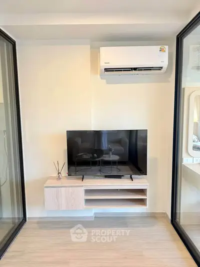Modern living room with sleek TV setup and air conditioning unit