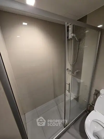 Modern bathroom with sleek glass shower enclosure and contemporary fixtures.