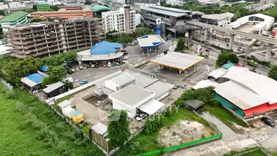 Aerial view of urban area with gas station and surrounding buildings, showcasing commercial real estate potential.