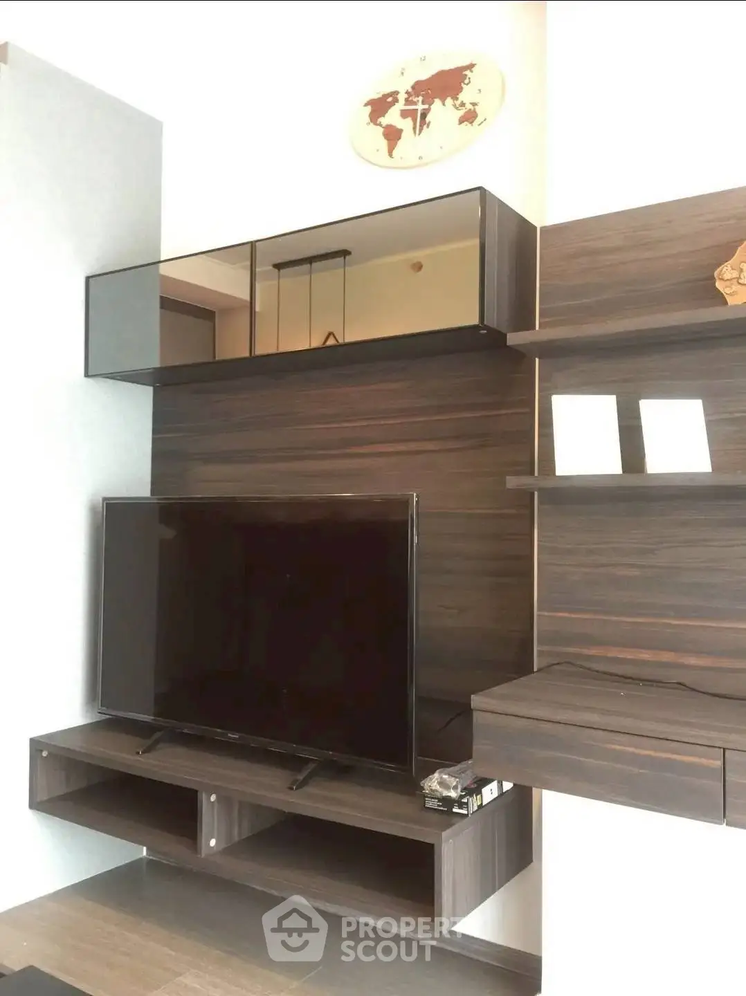Modern living room with sleek wooden TV unit and wall-mounted shelves
