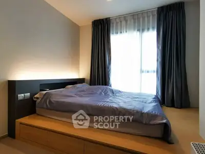 Modern bedroom with sleek design and natural light from large window.