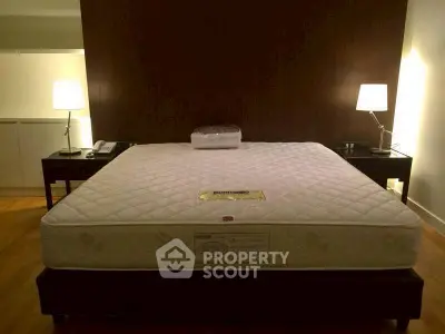 Spacious bedroom with elegant lighting and a comfortable bed setup.