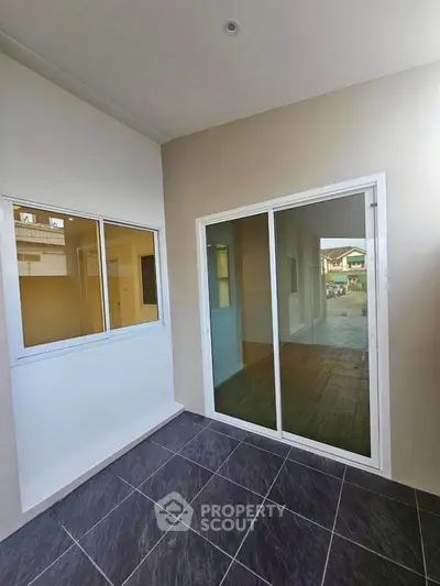 Modern balcony with sliding glass doors and tiled flooring in a contemporary home.