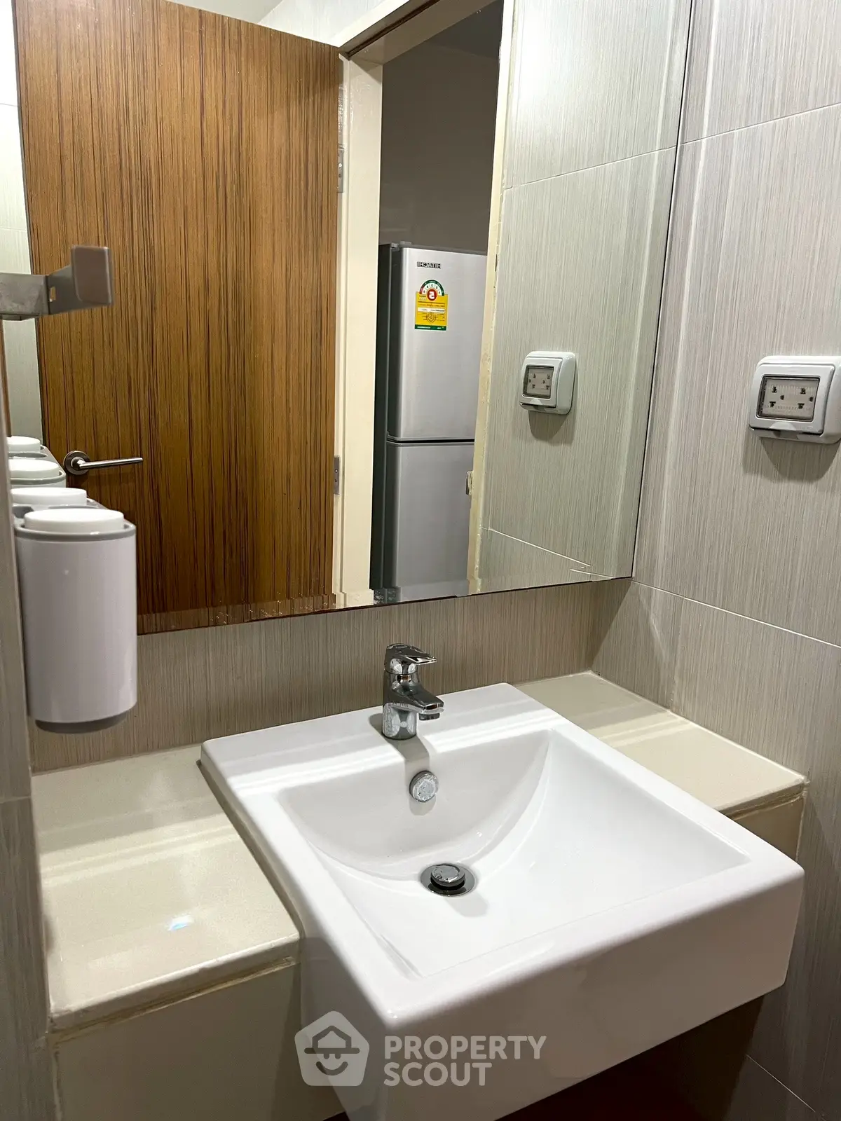 Modern bathroom with sleek sink and mirror, featuring contemporary design and neutral tones.