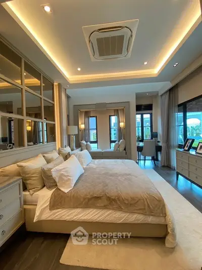 Luxurious bedroom with elegant decor and large windows offering natural light