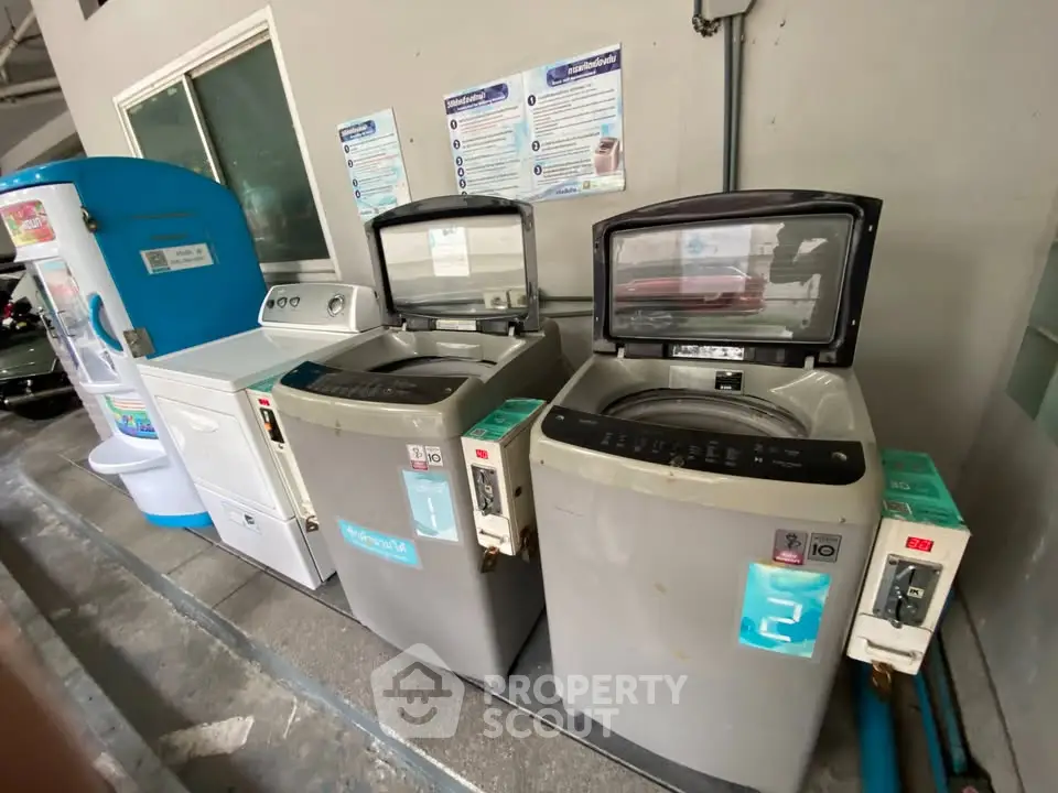Modern laundry area with washing machines and water dispenser in shared building space.