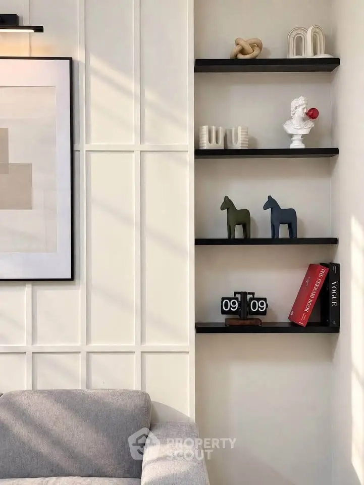 Stylish modern living room with elegant wall decor and cozy gray sofa.