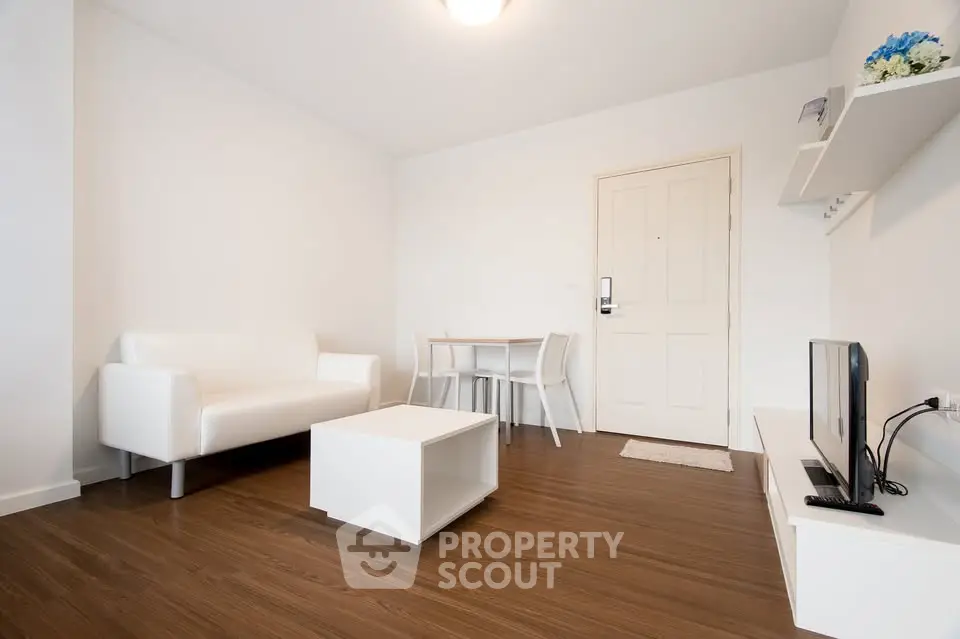 Modern minimalist living room with white furniture and wooden flooring