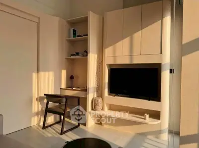 Modern living room with built-in TV unit and study desk in warm natural light.