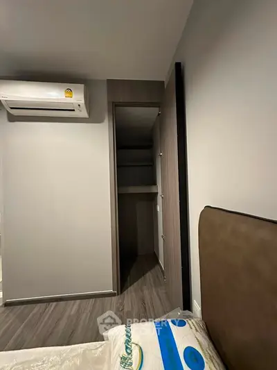 Modern bedroom with air conditioning and walk-in closet, featuring sleek design and neutral tones.