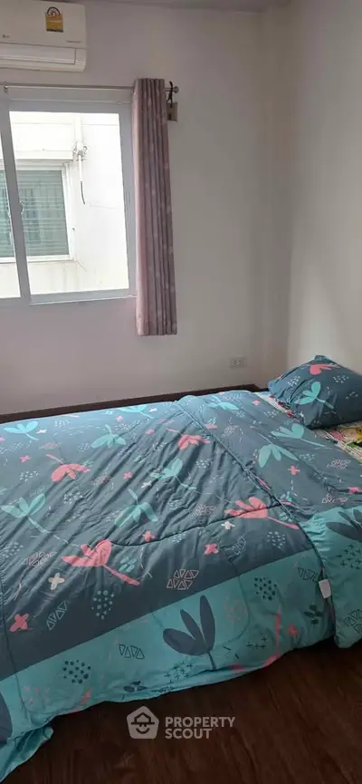 Cozy bedroom with floral bedding and natural light from window