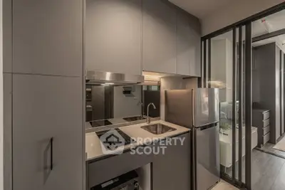 Modern compact kitchen with sleek cabinetry and built-in appliances in a stylish apartment.