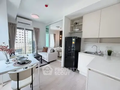 Modern open-plan living room and kitchen with balcony view in a stylish apartment.