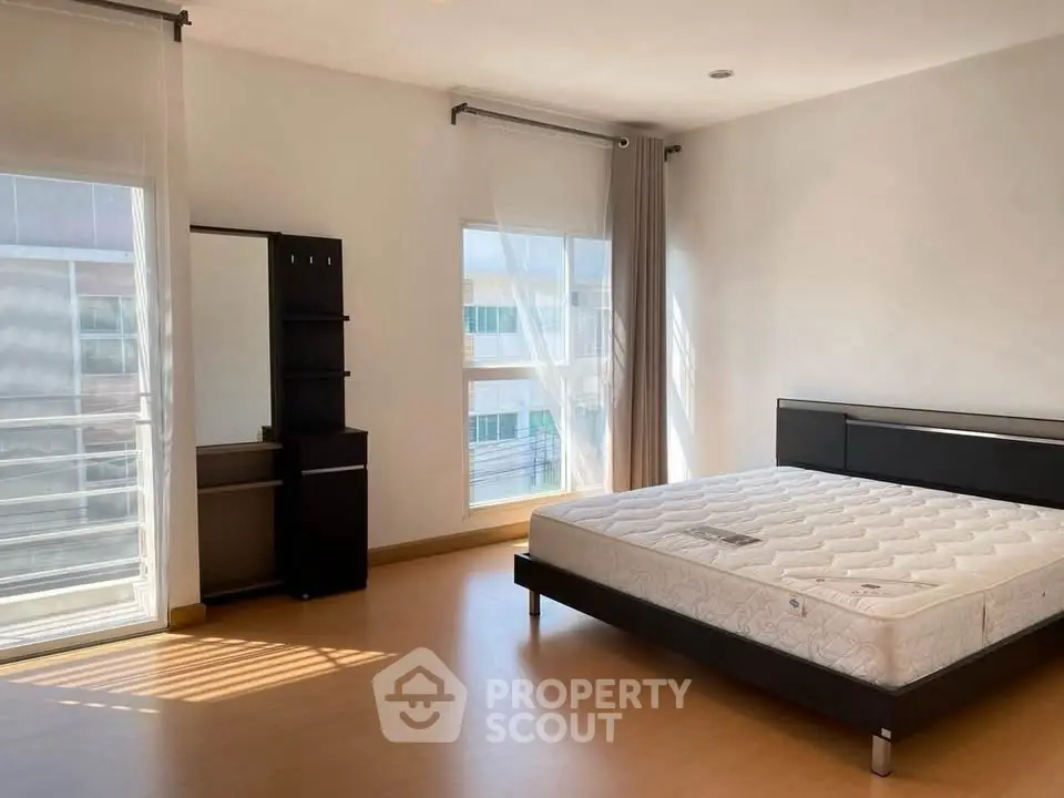 Spacious bedroom with large windows and modern furniture, perfect for natural light lovers.
