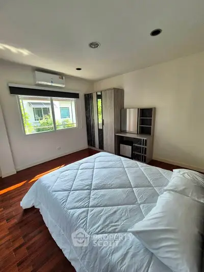 Spacious bedroom with modern decor and natural light, featuring a cozy bed and stylish wardrobe.