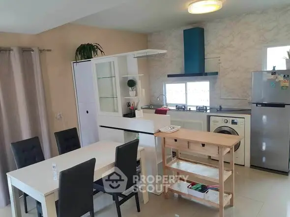 Modern kitchen and dining area with washing machine and sleek appliances.