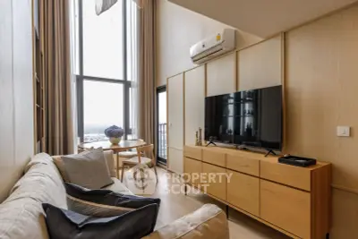 Modern living room with high ceilings and large windows offering a stunning view.
