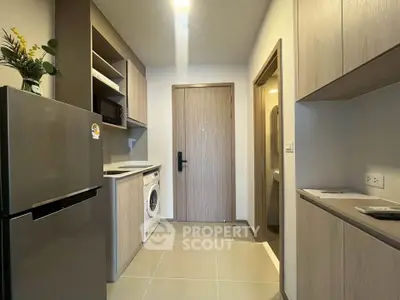 Modern kitchen with sleek appliances and ample storage in a stylish apartment.