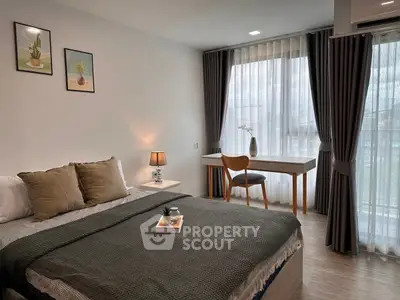 Modern bedroom with large window, stylish decor, and cozy ambiance