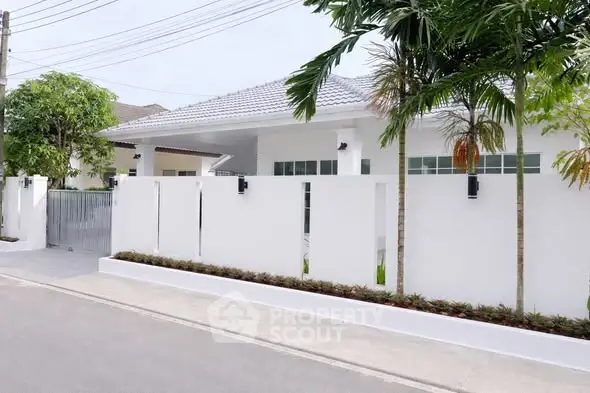 Modern white house exterior with lush greenery and sleek design