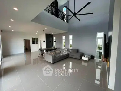 Spacious modern living room with high ceiling and sleek design, featuring a large sectional sofa and elegant dining area.