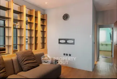 Modern living room with stylish shelving and cozy sofa in a contemporary apartment.
