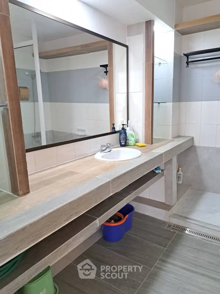Modern bathroom with large mirror and sleek wooden countertop