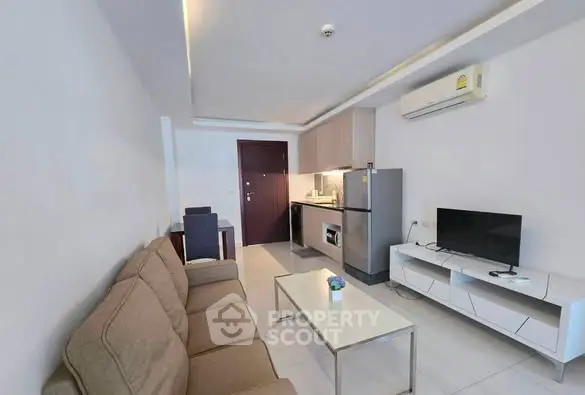 Modern living room with compact kitchen and sleek furniture in a cozy apartment.