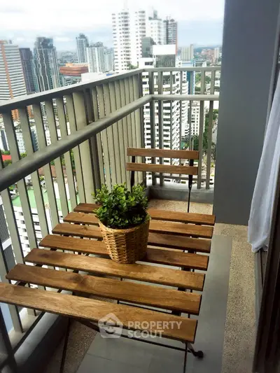 Charming balcony with wooden furniture and city skyline view, perfect for relaxation.