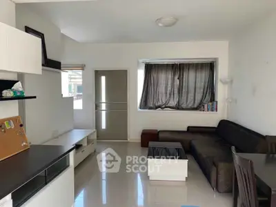 Modern living room with sleek furniture and natural light, perfect for cozy gatherings.
