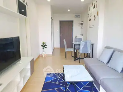 Modern living room with stylish decor and natural light, featuring a cozy sofa and sleek TV setup.