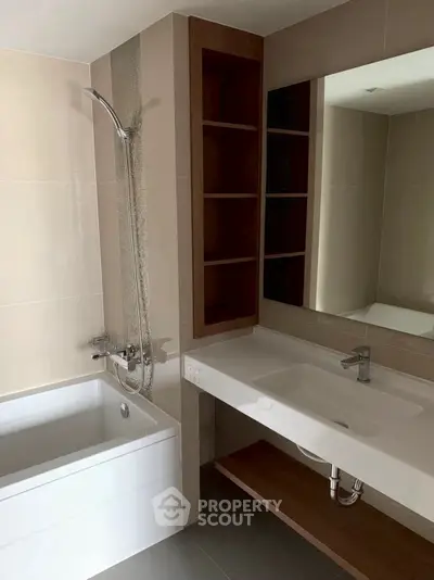 Modern bathroom with sleek bathtub and stylish sink area.