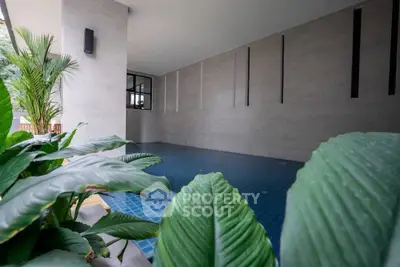 Modern indoor pool area with lush greenery and sleek design