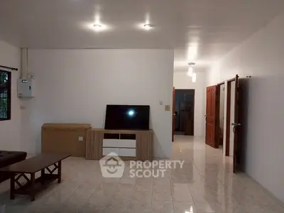 Spacious living room with modern furniture and tiled flooring in a well-lit home.