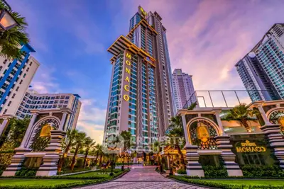 Luxurious high-rise building with stunning architecture and lush landscaping at sunset.