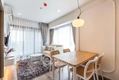 Modern living room with cozy dining area and large windows in a stylish apartment.