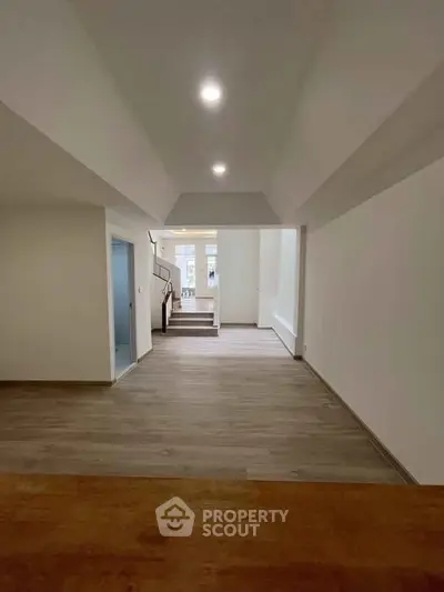 Spacious modern interior with wooden flooring and ample natural light, ideal for customization.