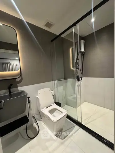 Modern bathroom with sleek design, glass shower, and stylish fixtures.