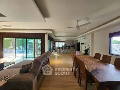 Spacious open-plan living and dining area with modern furnishings and large windows.