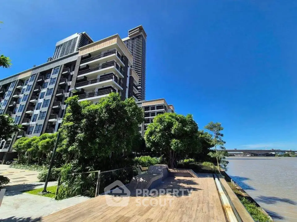 Luxurious riverside apartment building with stunning views and lush greenery.
