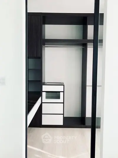 Spacious modern walk-in closet with sleek dark wood finish and ample storage space.