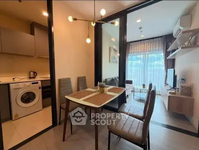 Modern apartment with open kitchen and cozy living area, featuring stylish dining set and natural light.