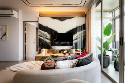 Luxurious living room with modern decor and large windows opening to a balcony.