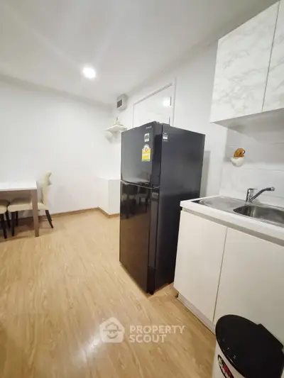 Modern kitchen with sleek black fridge and white cabinetry