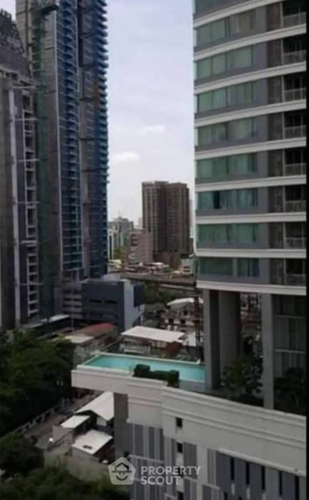 Stunning urban view with modern high-rise buildings and a luxurious pool area.