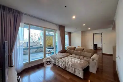 Spacious living room with large windows and outdoor balcony access