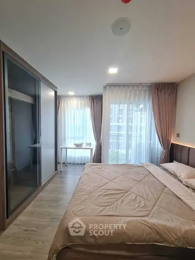 Spacious bedroom with large windows and modern decor in a stylish apartment.