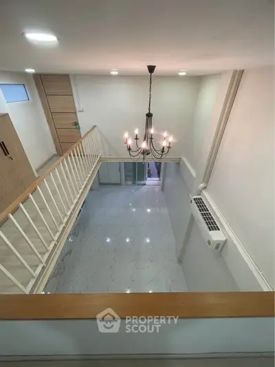 Spacious two-story living area with elegant chandelier and modern design