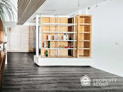 Modern living room with sleek wooden flooring and stylish open shelving unit