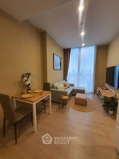 Cozy living room with modern decor, large window, and stylish furniture in a contemporary apartment.